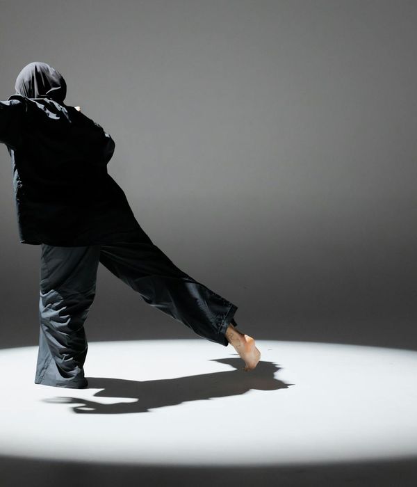 Woman performing graceful balance movement in a dark studio